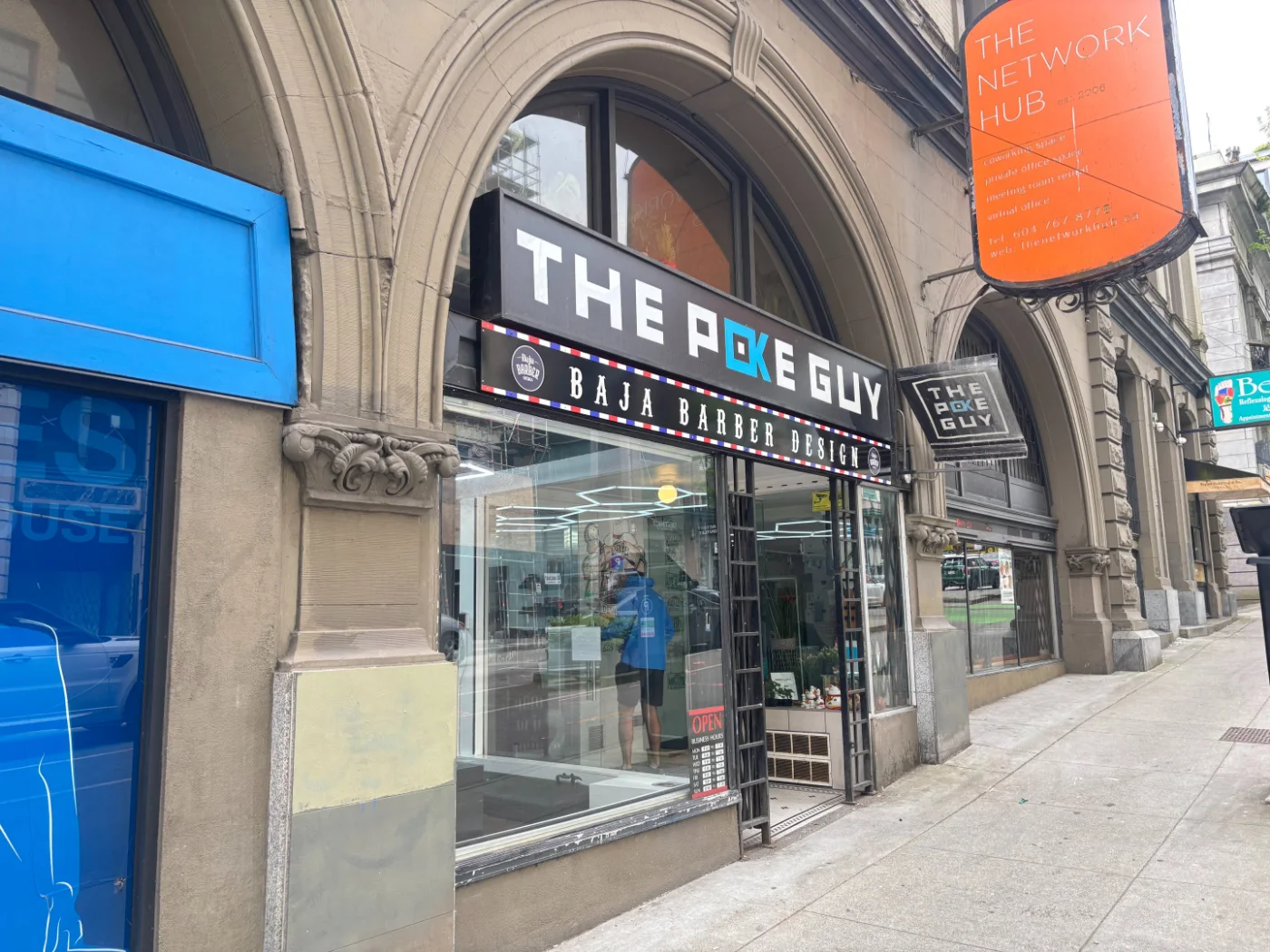 Blue projecting storefront sign on a brick building